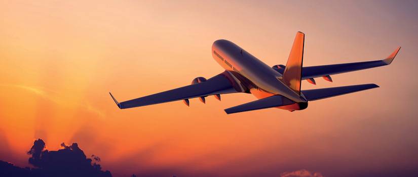 plane flying into orange sunset flies using custom machined parts by Lange Grinding and Machining serving aerospace industry in Ohio, Pennsylvania, and Michigan