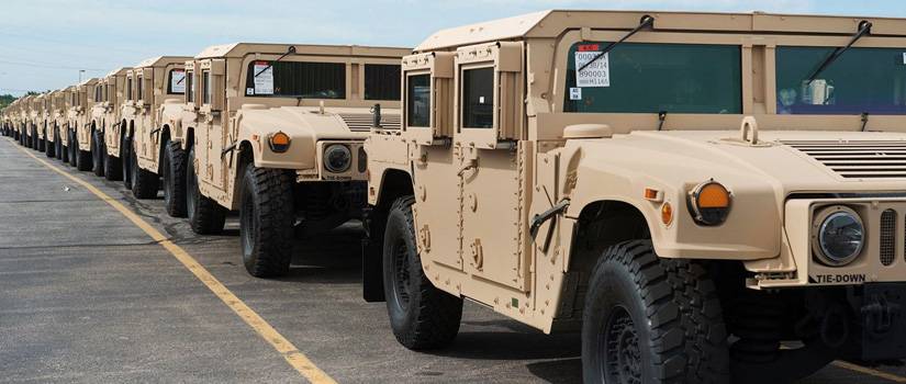 tan military trucks in a line run on machined parts by Ohio machine shop Lange Grinding and Machining